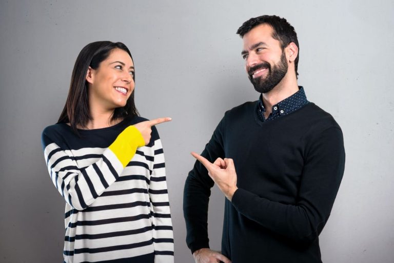 Two people pointing at each other and smiling playfully