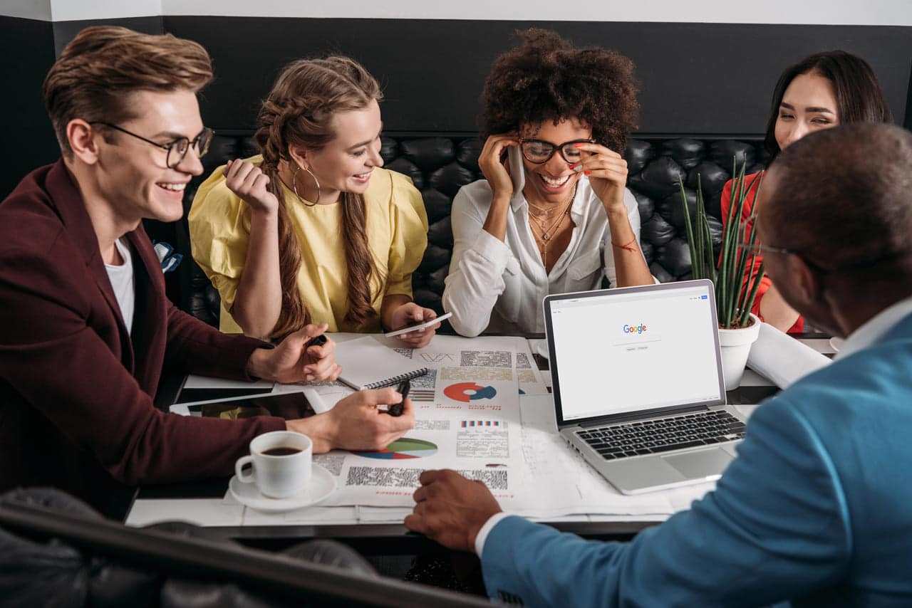 Group of colleagues having a discussion around a laptop