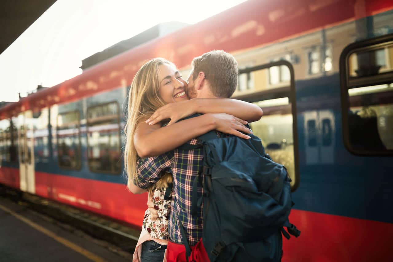 A couple embracing joyfully at a train station