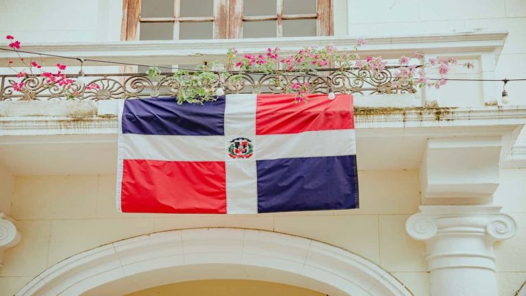 Dominican Republic flag hanging on a balcony adorned with flowers