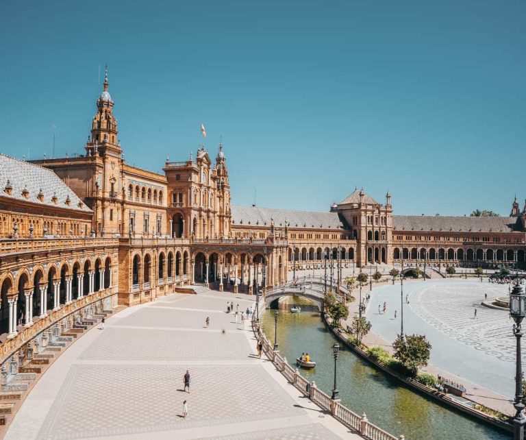 Large plaza with grand arched building and canal