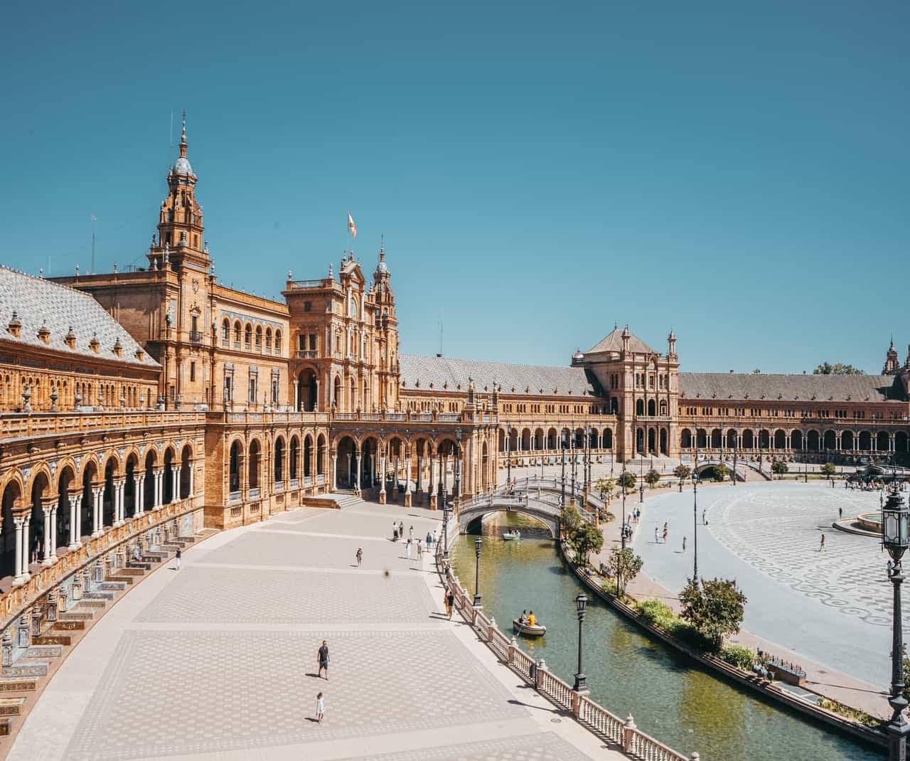 Large plaza with grand arched building and canal