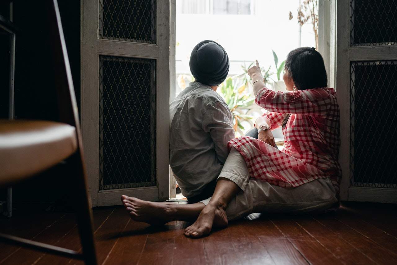 Two people sitting on the floor near an open door