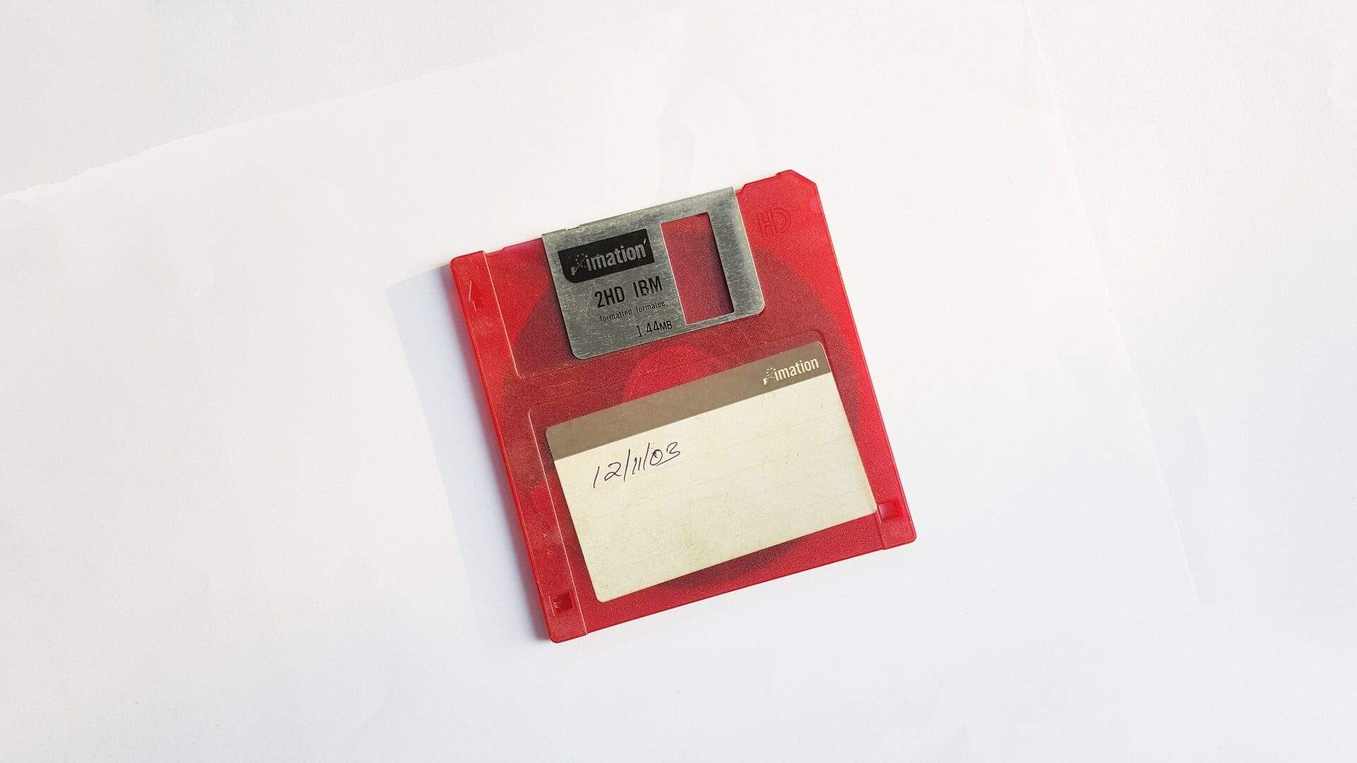 Red floppy disk labeled with a date