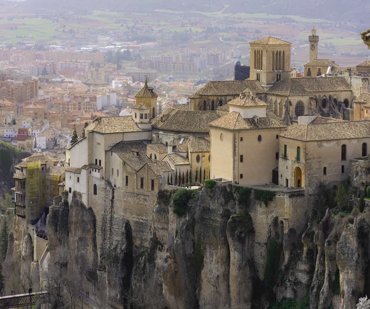 Historic buildings perched on cliffs overlooking a city