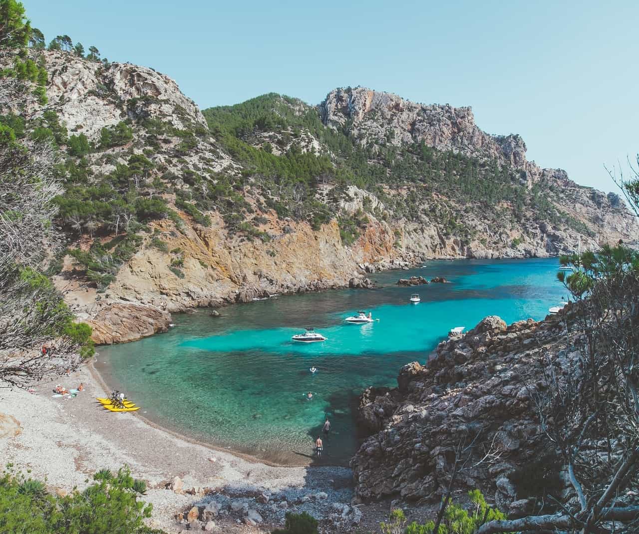 Secluded beach with boats and rocky coastline