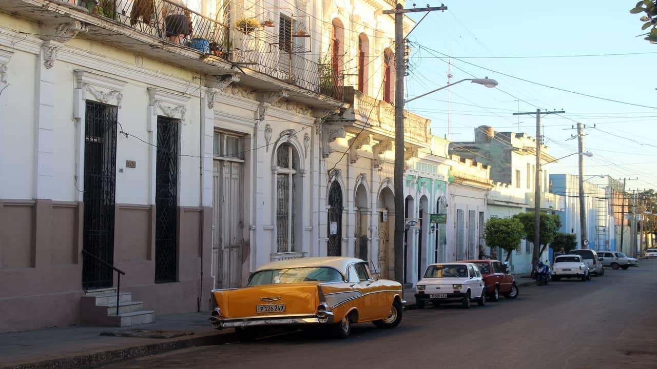 Yellow vintage car parked along old city street