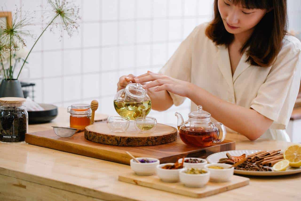 Woman pouring tea into glass cups on a table