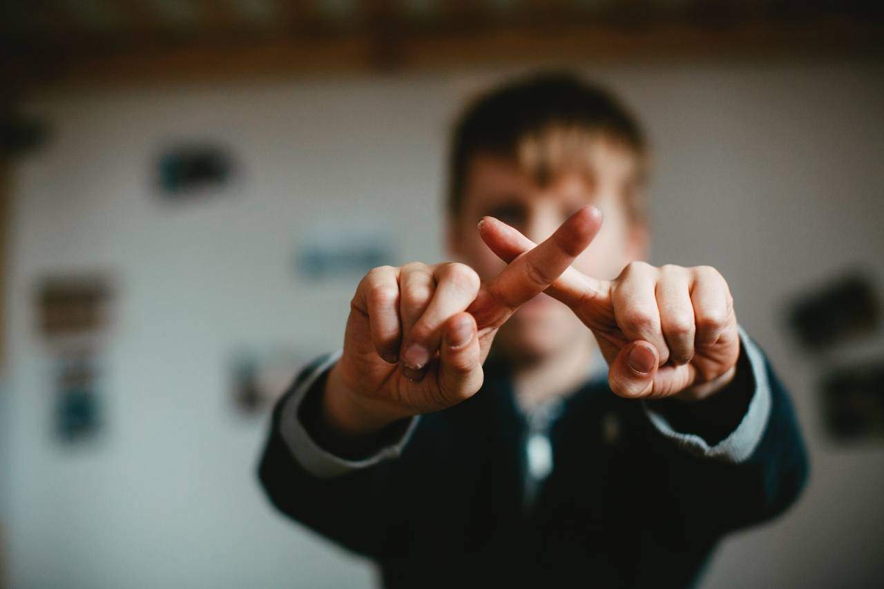 Child making a crossed finger gesture