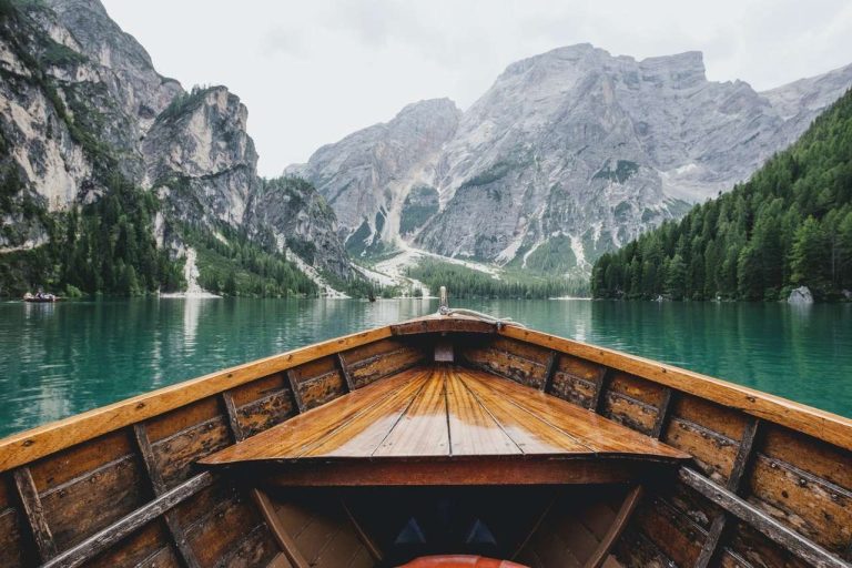 Boat heading towards a lake surrounded by mountains
