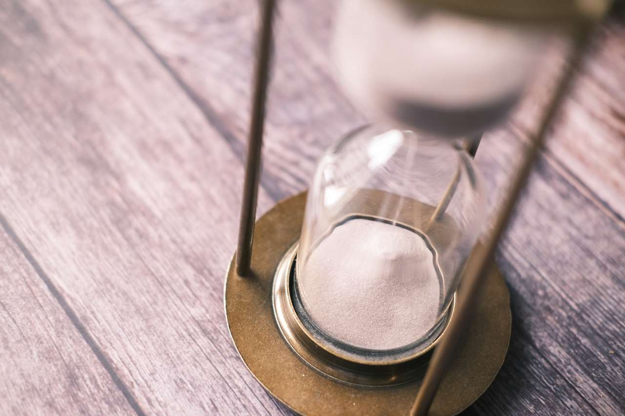 Close-up view of an hourglass on wooden surface