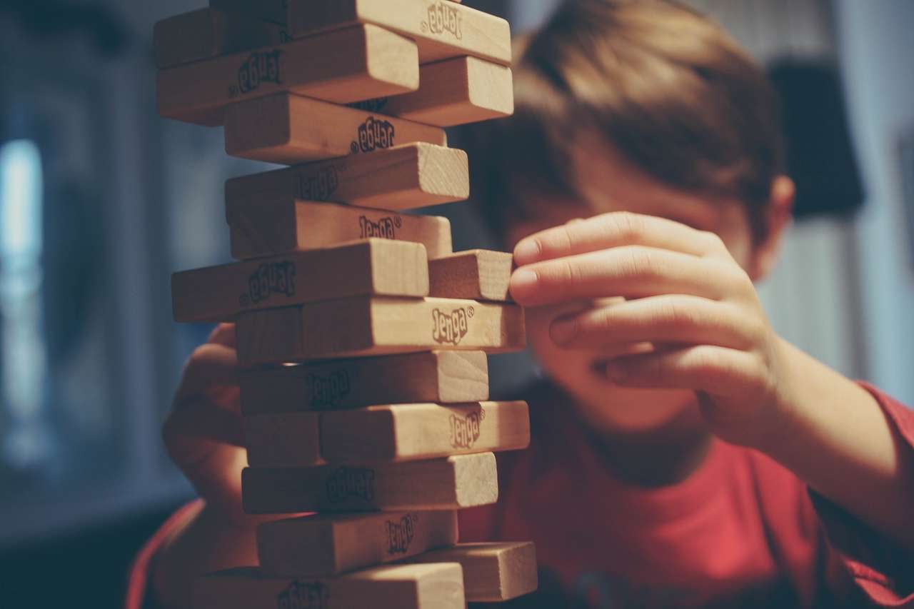 Child playing with a Jenga block tower