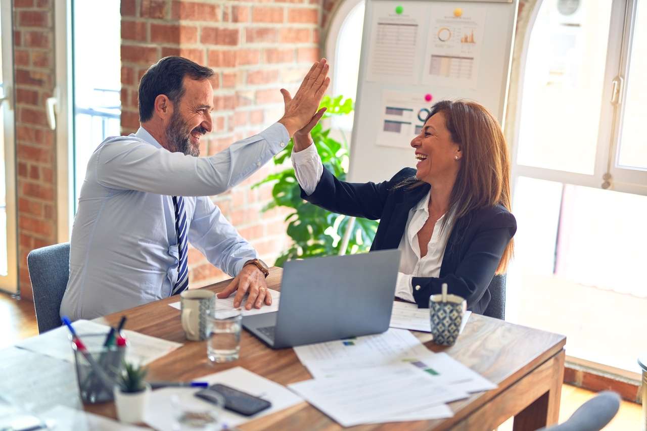 Two colleagues giving a high five in an office
