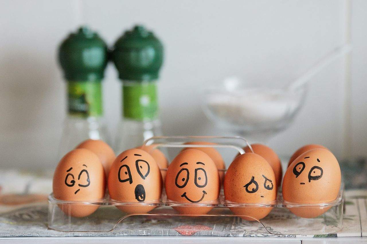 Eggs with drawn faces in a transparent container