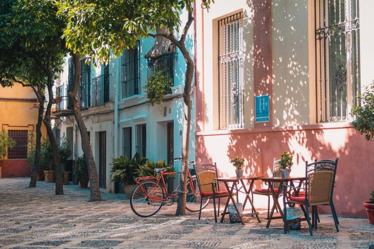 Bicycle and outdoor café seating in a sunlit alley