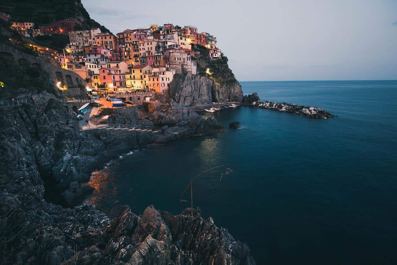 Houses on a cliffside overlooking a calm ocean