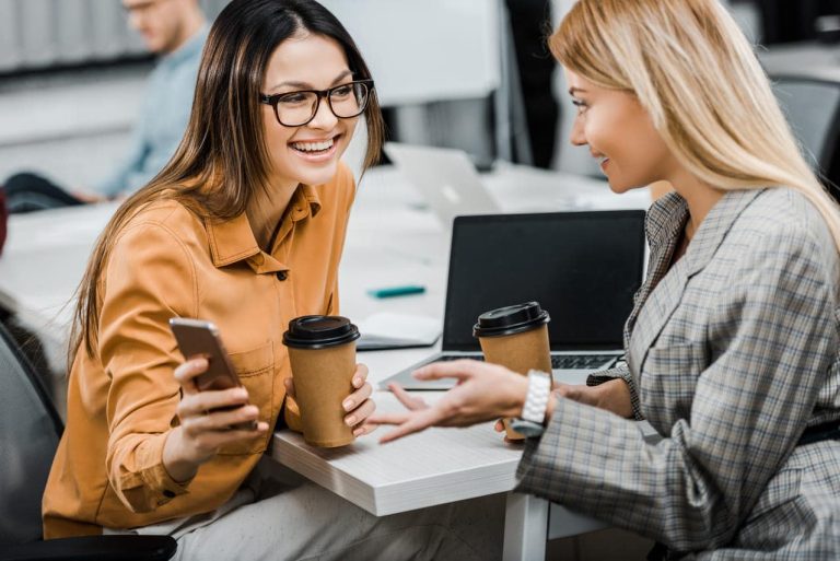 Two women in an office having coffee and talking