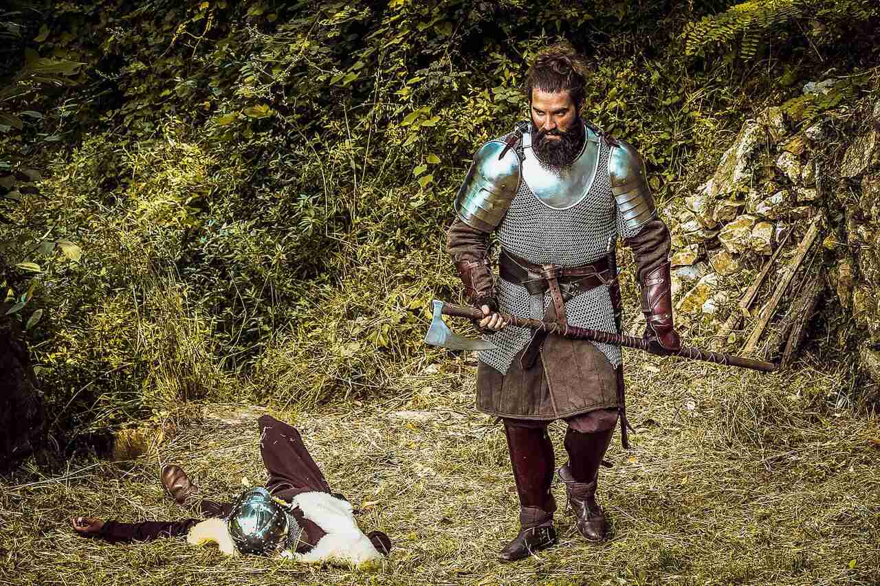 Medieval knight holding a battle axe near fallen enemy