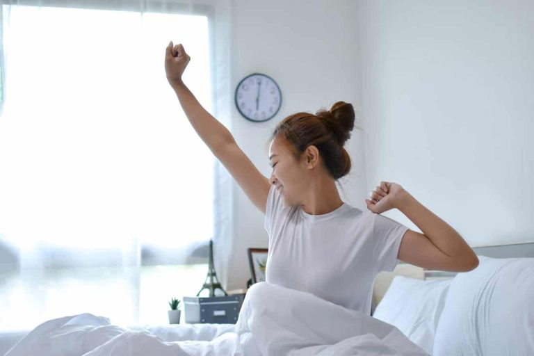 Woman stretching in bed after waking up in the morning
