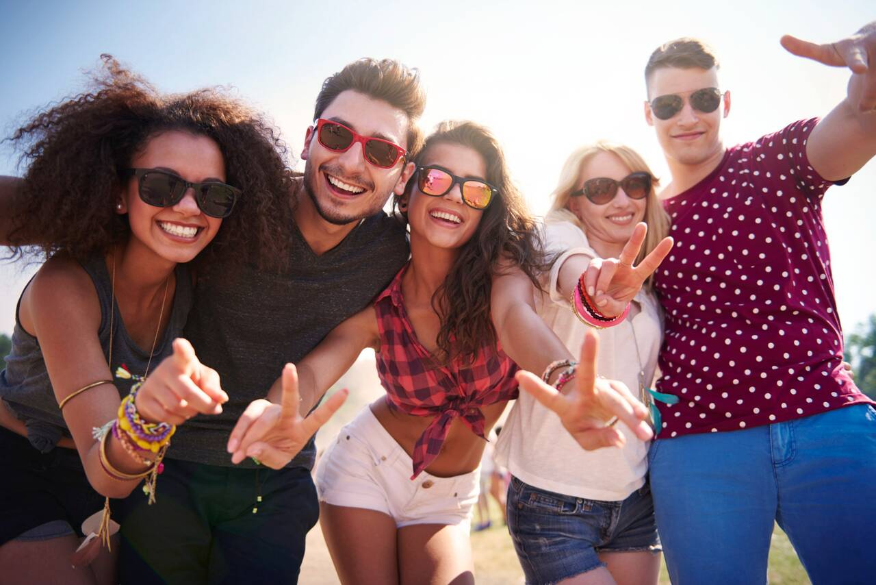 Friends posing together, wearing sunglasses, and smiling