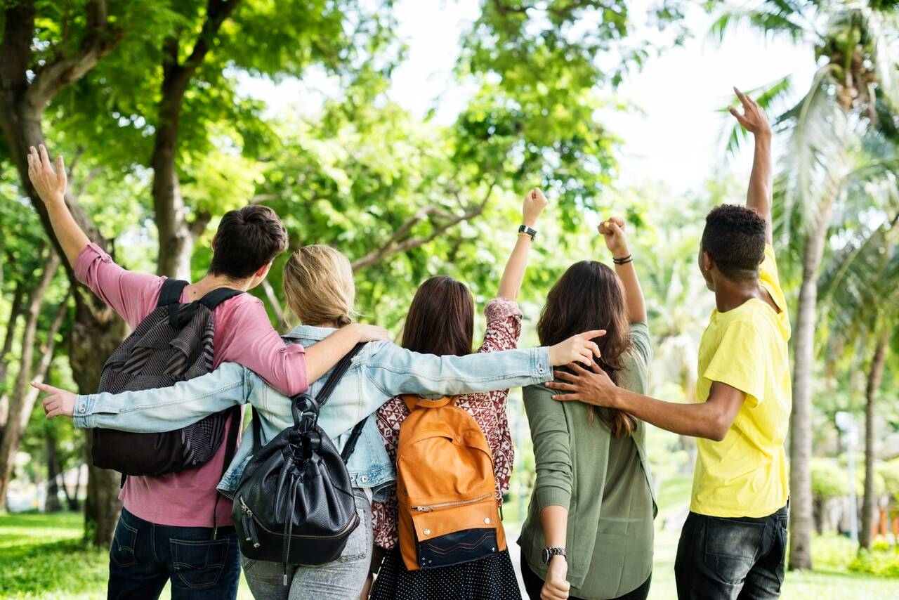 Group of friends with backpacks walking outdoors