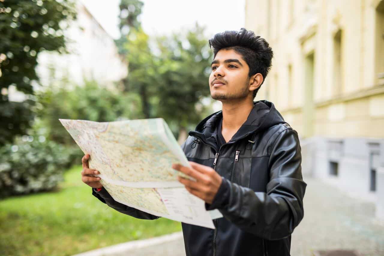 Person holding a map outdoors while looking ahead