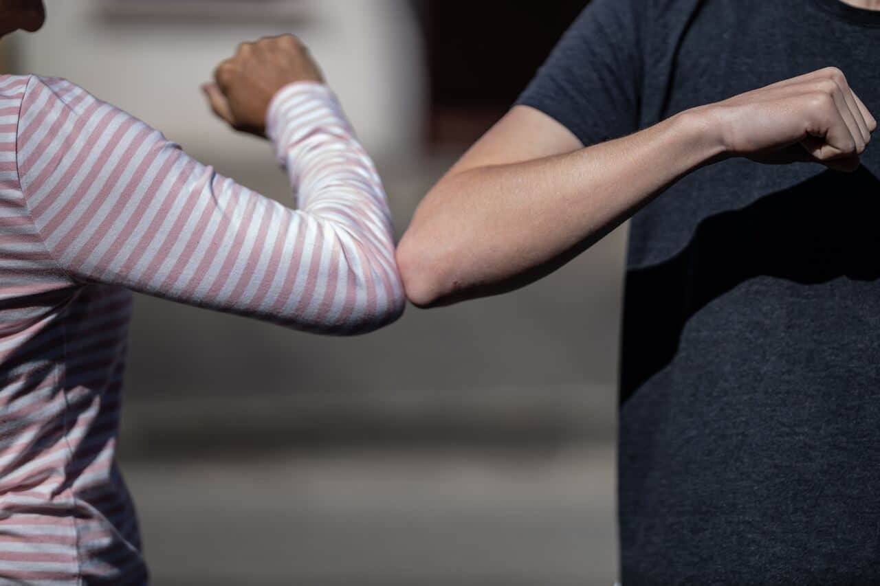 two people touching elbows for a greeting