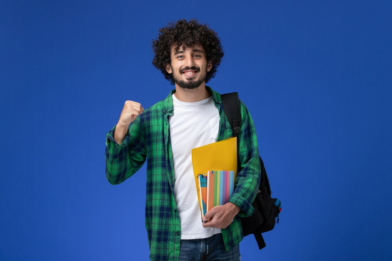 Smiling student with a backpack holding books