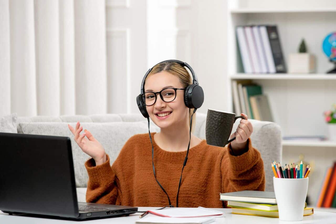 Smiling woman with headphones holding a coffee cup
