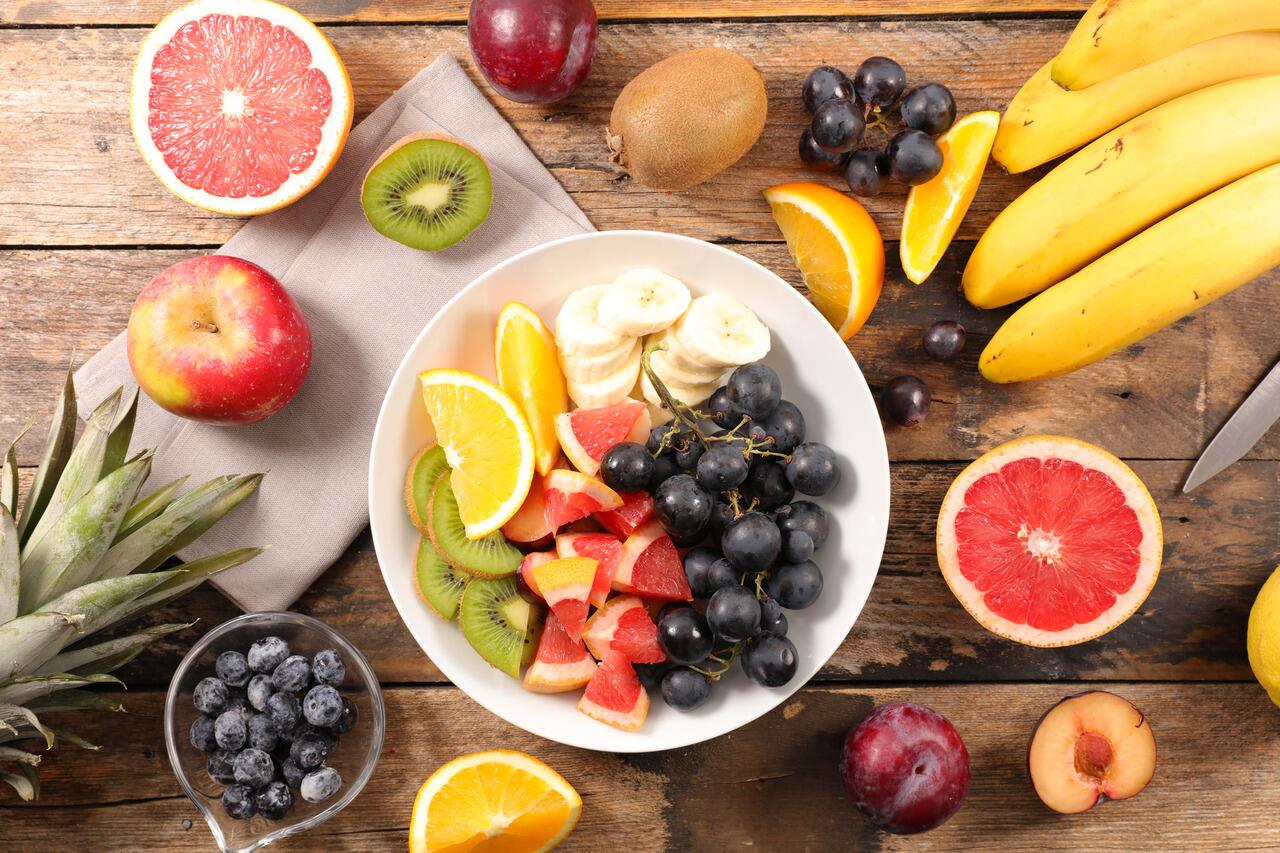A bowl of mixed fruit on a wooden table