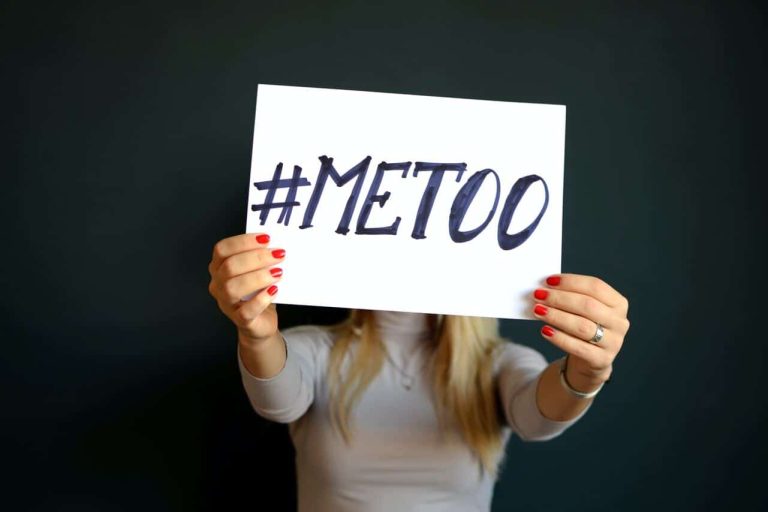 Person holding a #MeToo sign with red nails