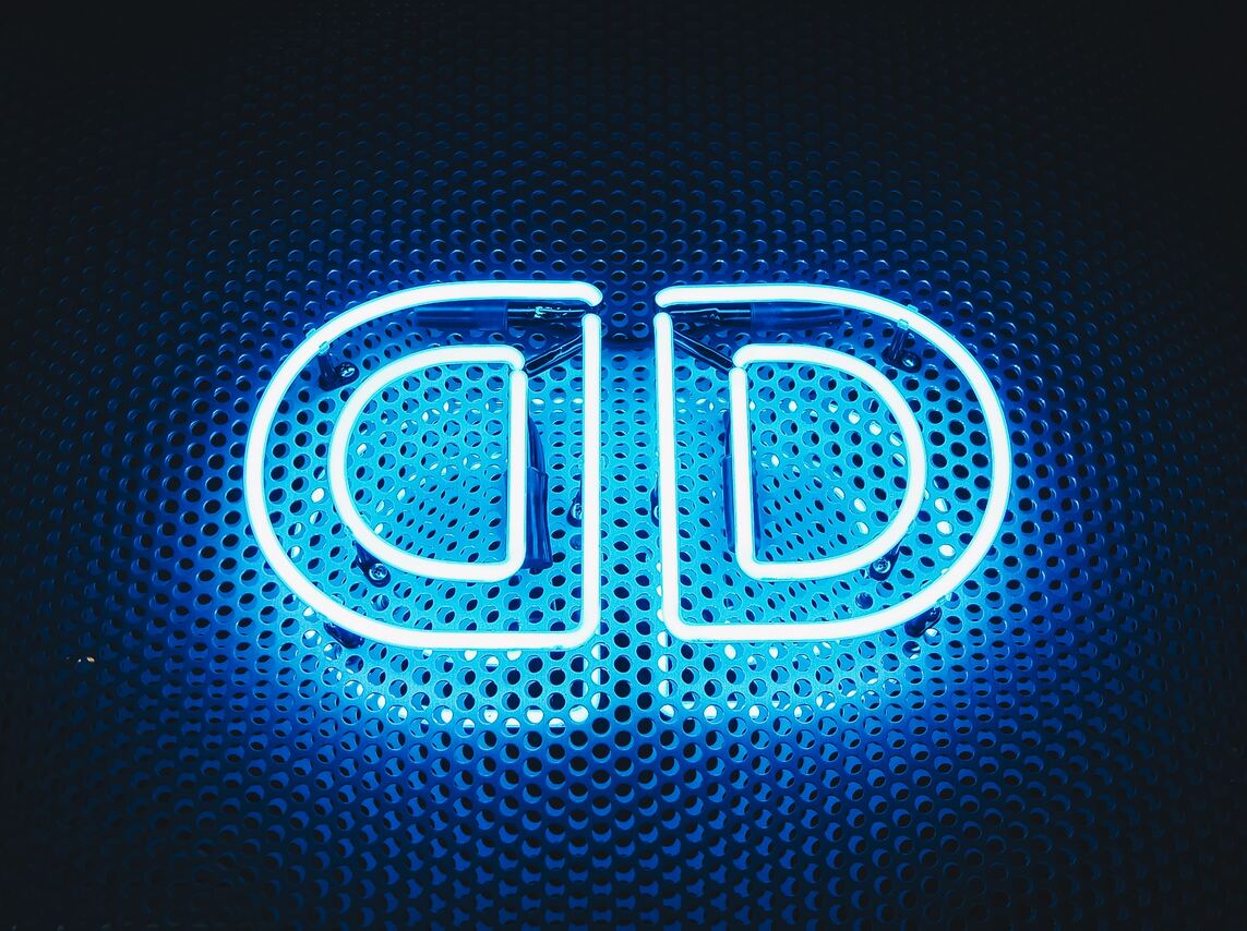 Blue neon letters on perforated metal background