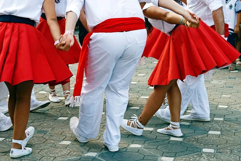 A group of people in red and white traditional outfits dancing