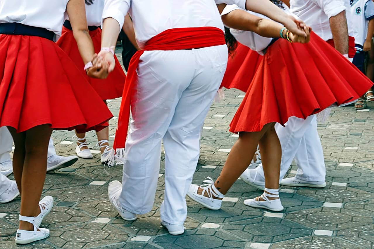 A group of people in red and white traditional outfits dancing