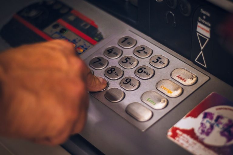Hand pressing button on an ATM keypad