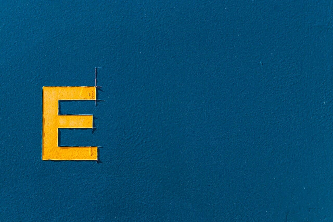 Yellow letter "E" displayed on a blue textured background
