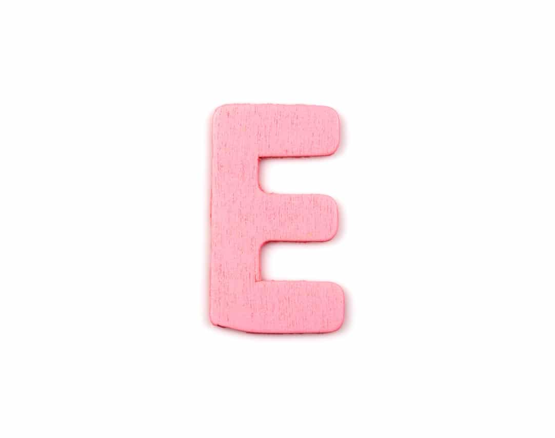 Pink wooden letter E on white background
