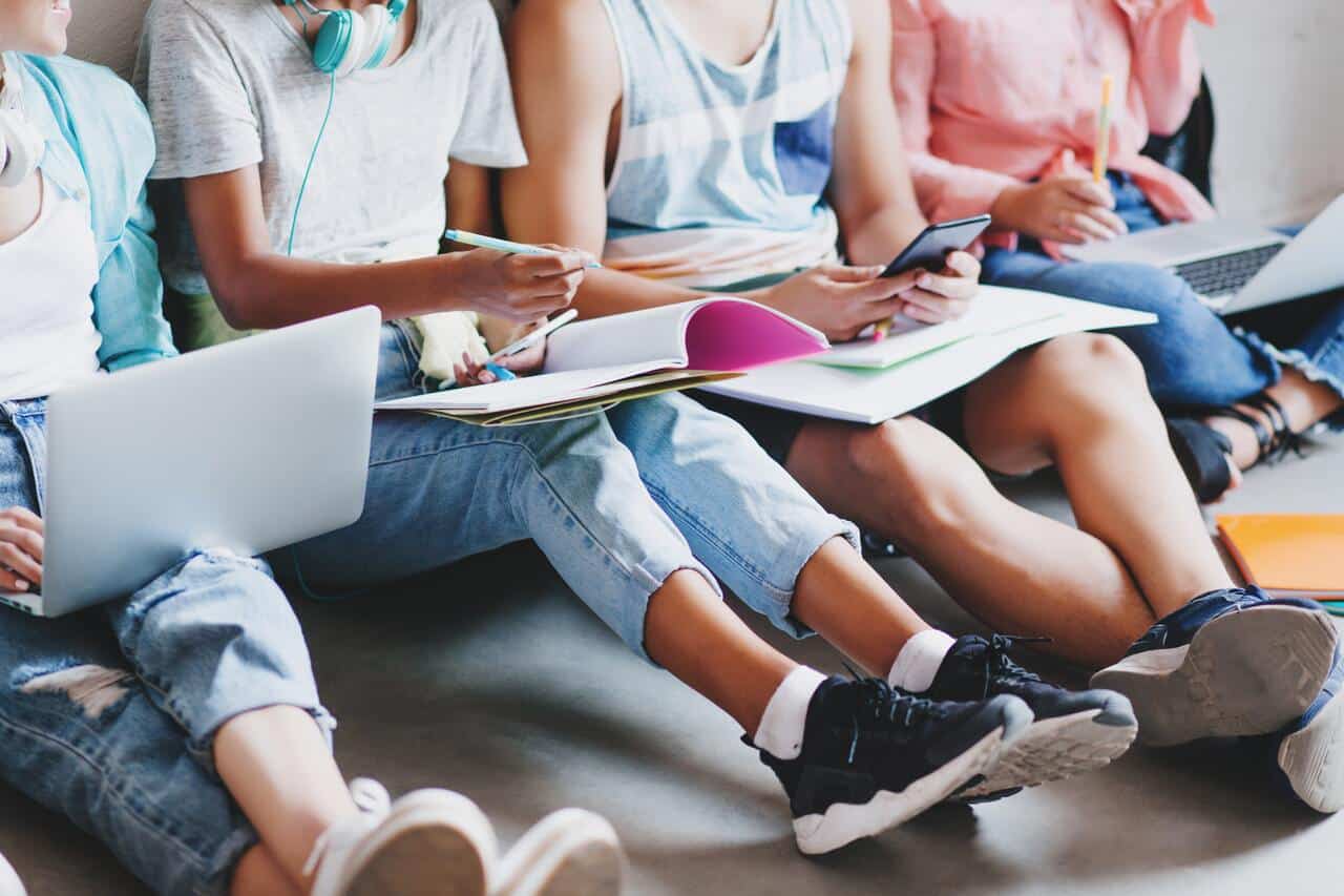 Group of students studying with laptops and notebooks