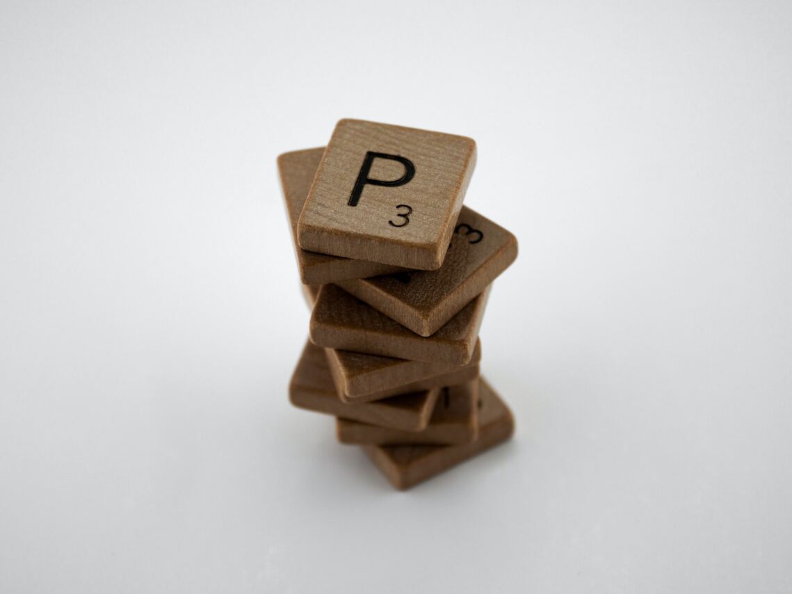 Stack of wooden Scrabble tiles with letter P