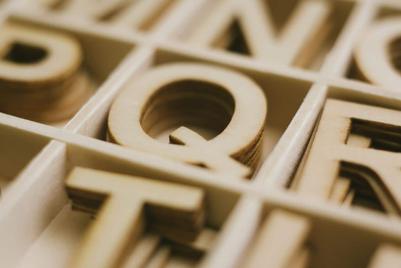 Wooden letter Q stacked inside an organized box
