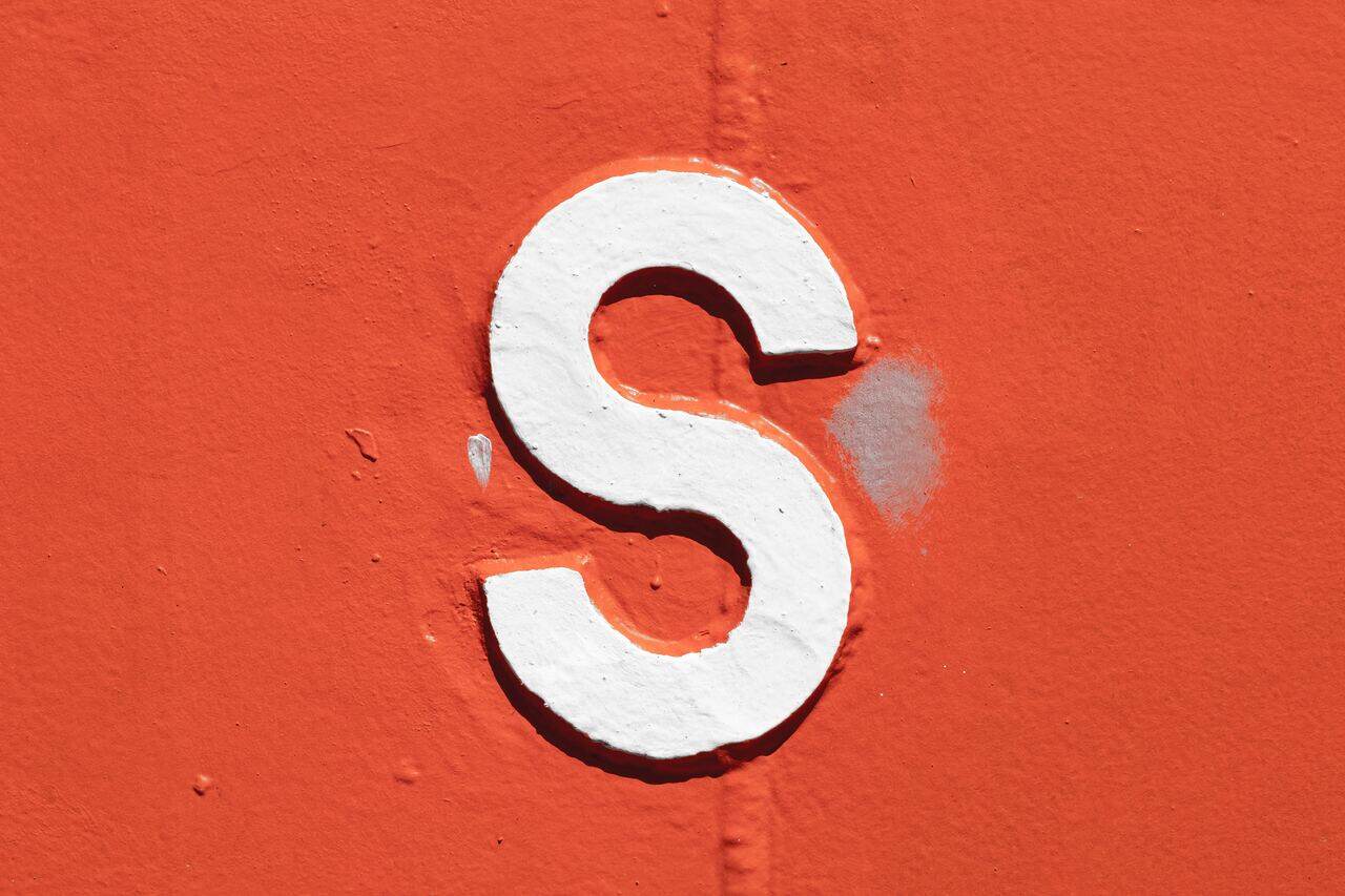 White letter S on an orange wall