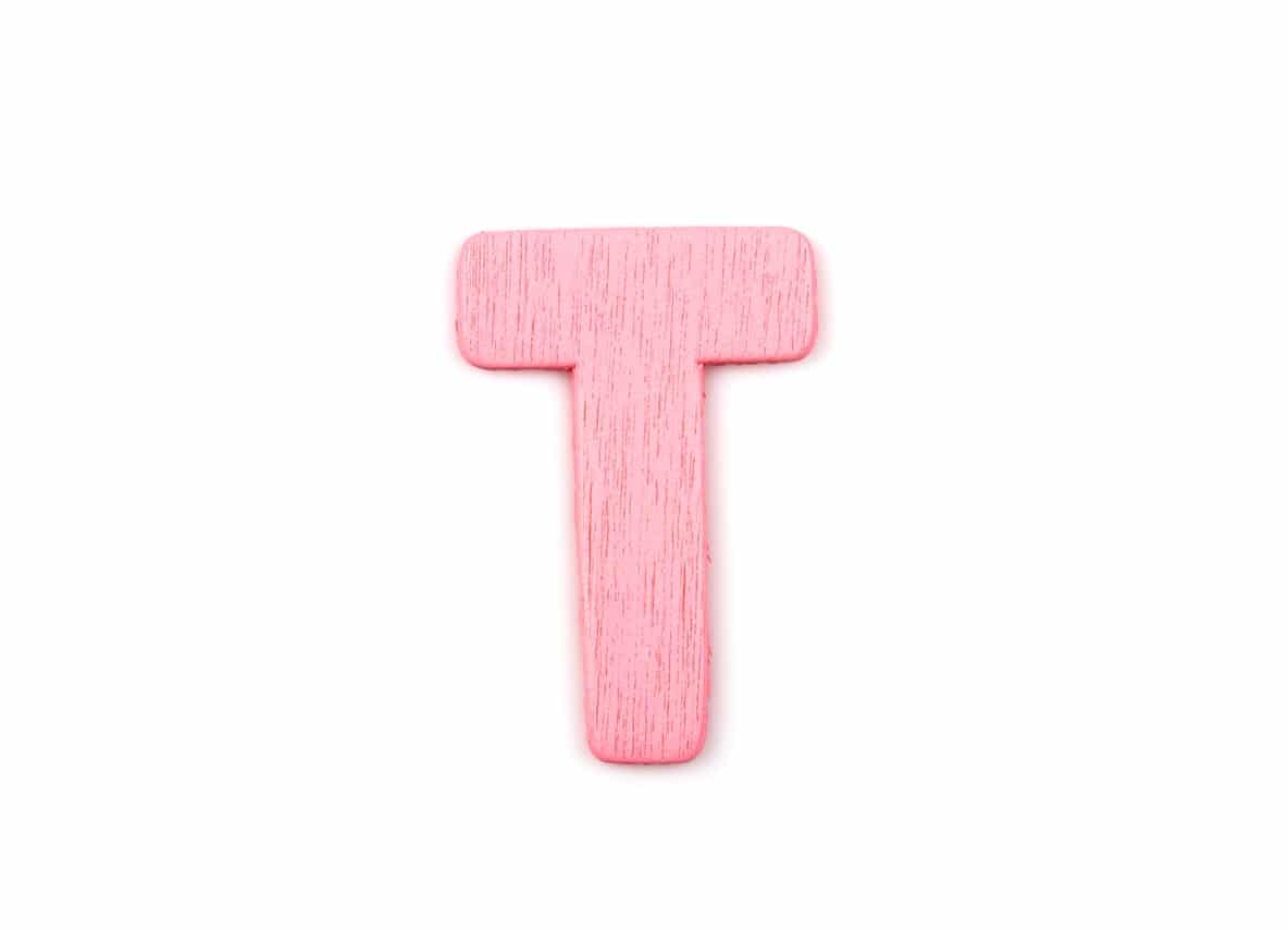 Pink wooden letter T on white background