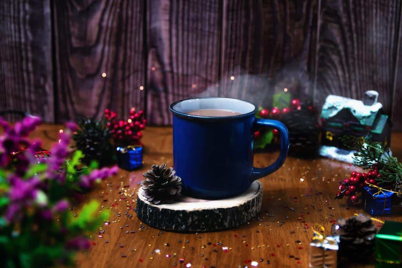 Blue mug on wooden coaster with festive decorations