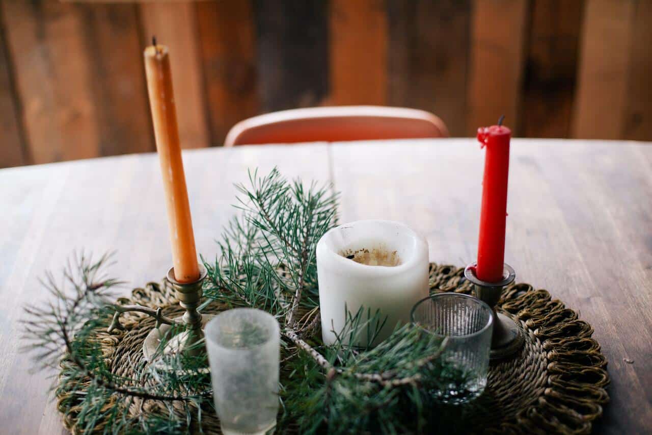 Candle arrangement with pine branches on a wooden table