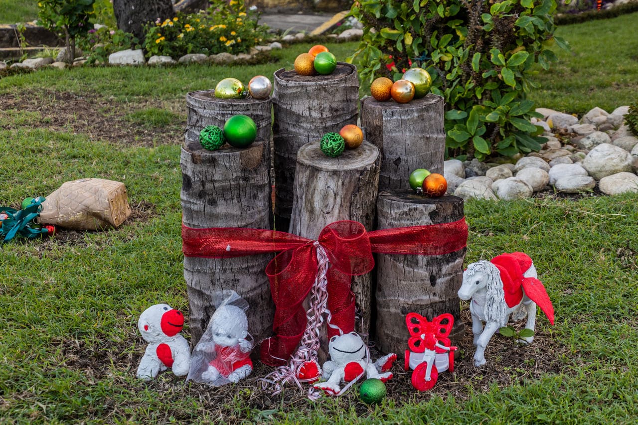 Stacked logs with Christmas decorations and ornaments.