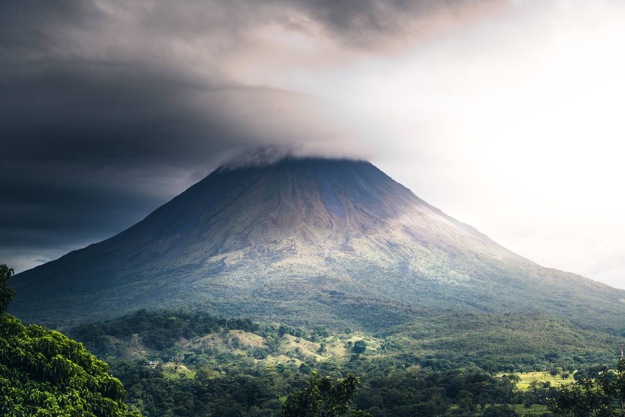 Cloud-covered volcanic peak surrounded by lush greenery