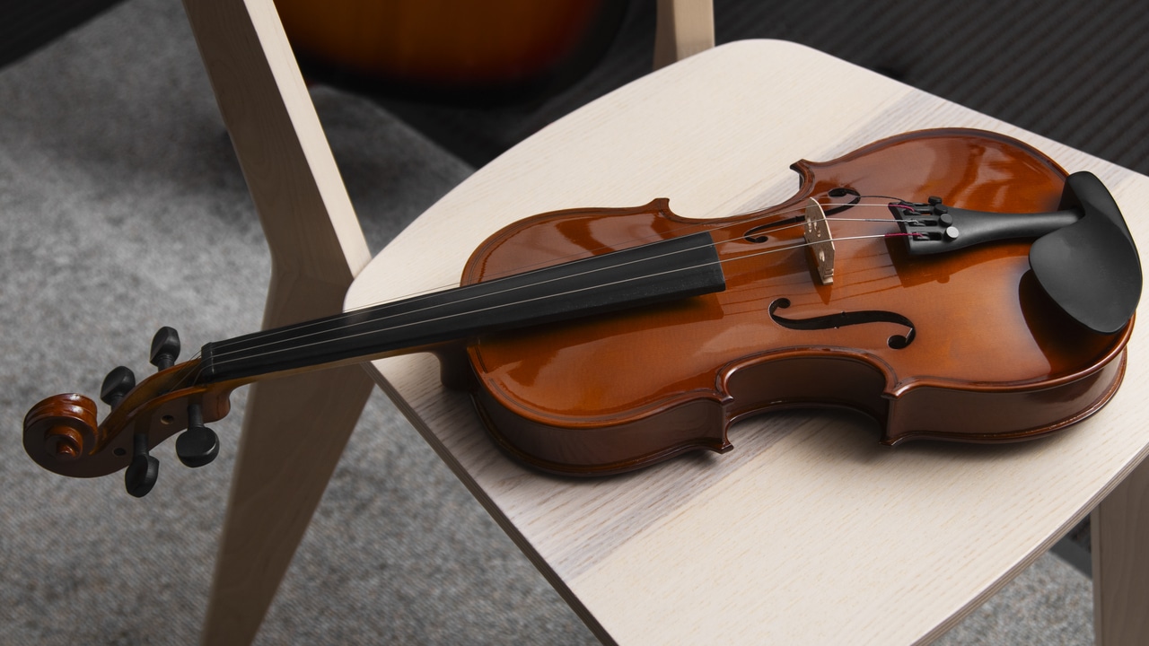Violin placed on a light wooden chair