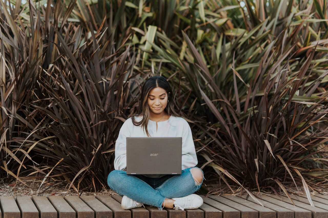 Person sitting outdoors with a laptop