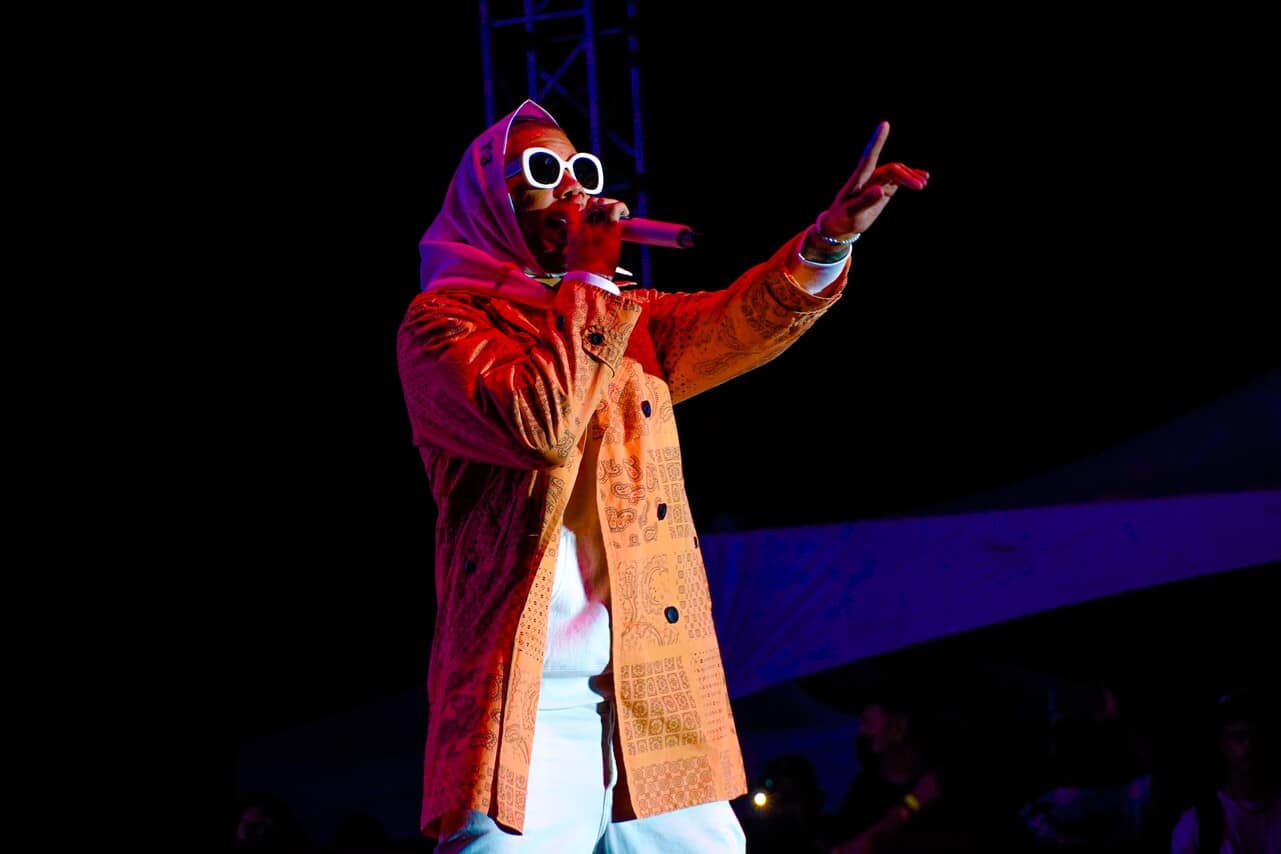 Performer wearing sunglasses and headscarf on stage