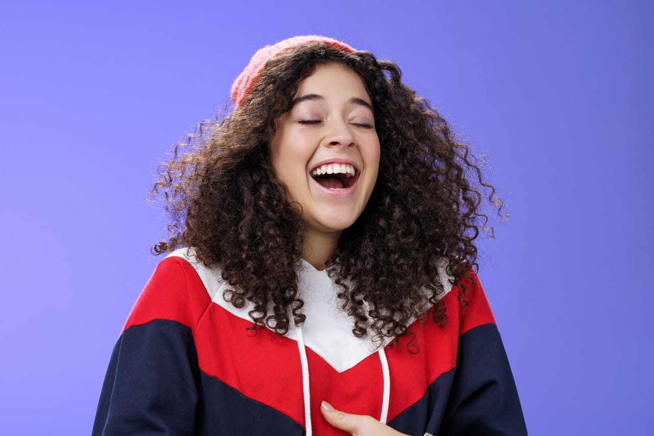 A young woman laughing with her eyes closed